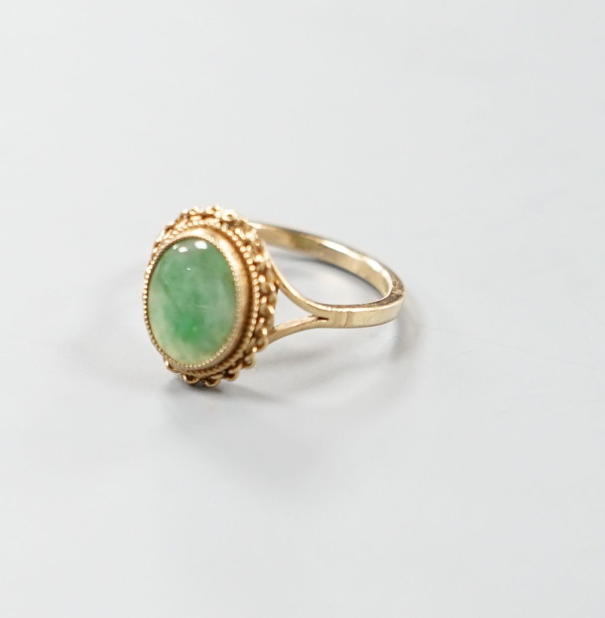 A 9ct gold and cabochon jade set oval ring, size M/N, gross weight 3 grams.